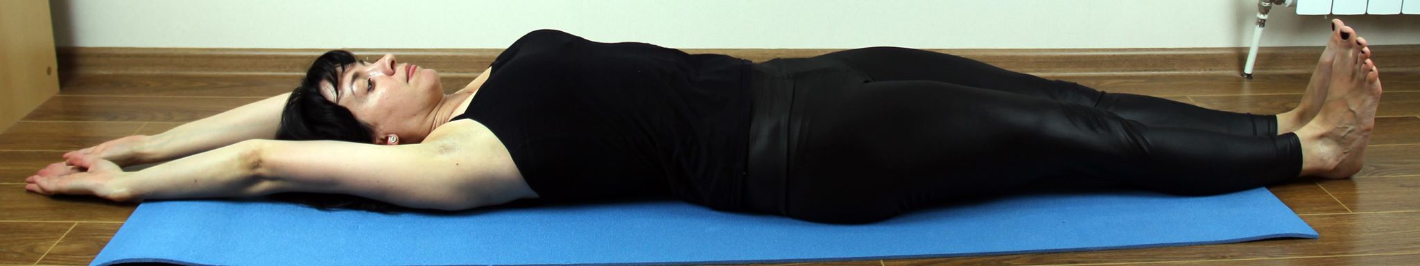 Ложимся на спину с вытянутыми вдоль тела руками. На медленном вдохе тянемся прямыми руками за голову на медленном вдохе. Одновременно максимально тянуть носки на себя. Во время упражнения поясница должна быть прижата к полу. Расслабиться нужно на выдохе, оставляя руки за головой ладонями вверх. Повторять три-пять раз